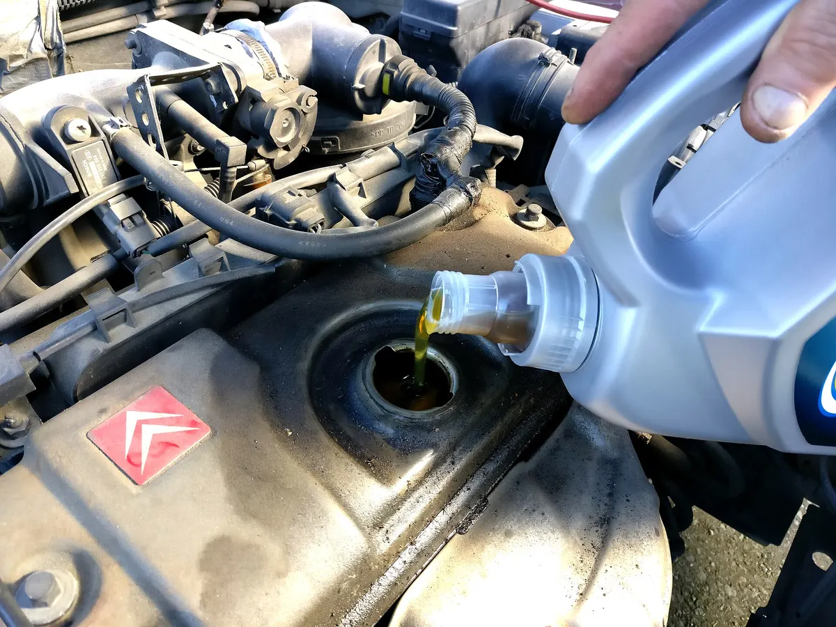 Fresh engine oil being poured into an engine